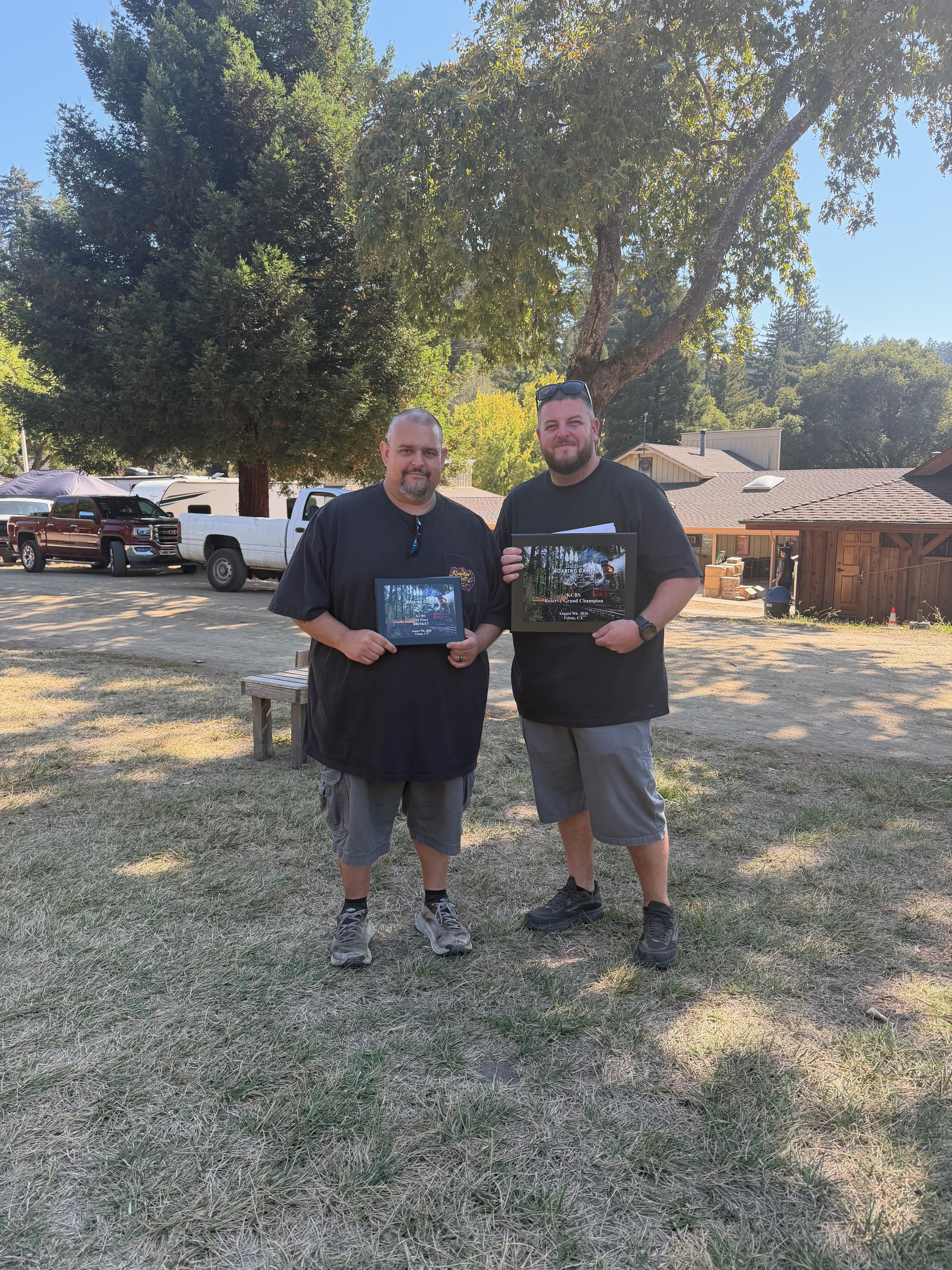 Two R-A-D Competition BBQ team members holding the Overall Reserve Grand Champion plaque in Felton, California